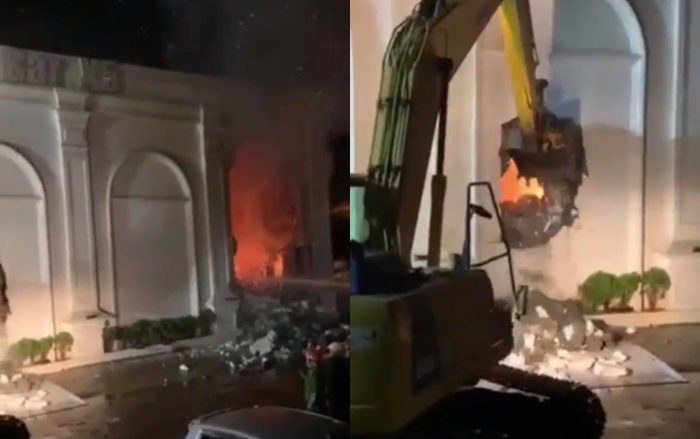 Lực lượng chức năng phá tường dập lửa.