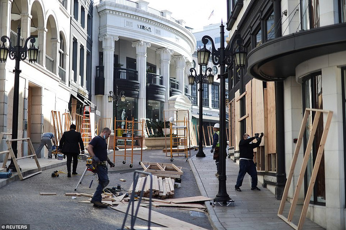Nhân viên gia cố cửa hàng trên đường Rodeo Drive, Los Angeles trước ngày bầu cử.