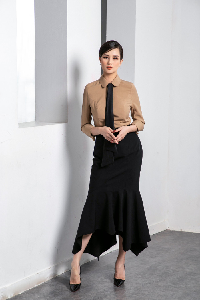 Áo sơ mi tinh tế thắt cà vạt mix kèm với chân váy so le đen tạo nên vẻ ngoài tinh tế là gợi ý không tệ cho các nàng công  sở 