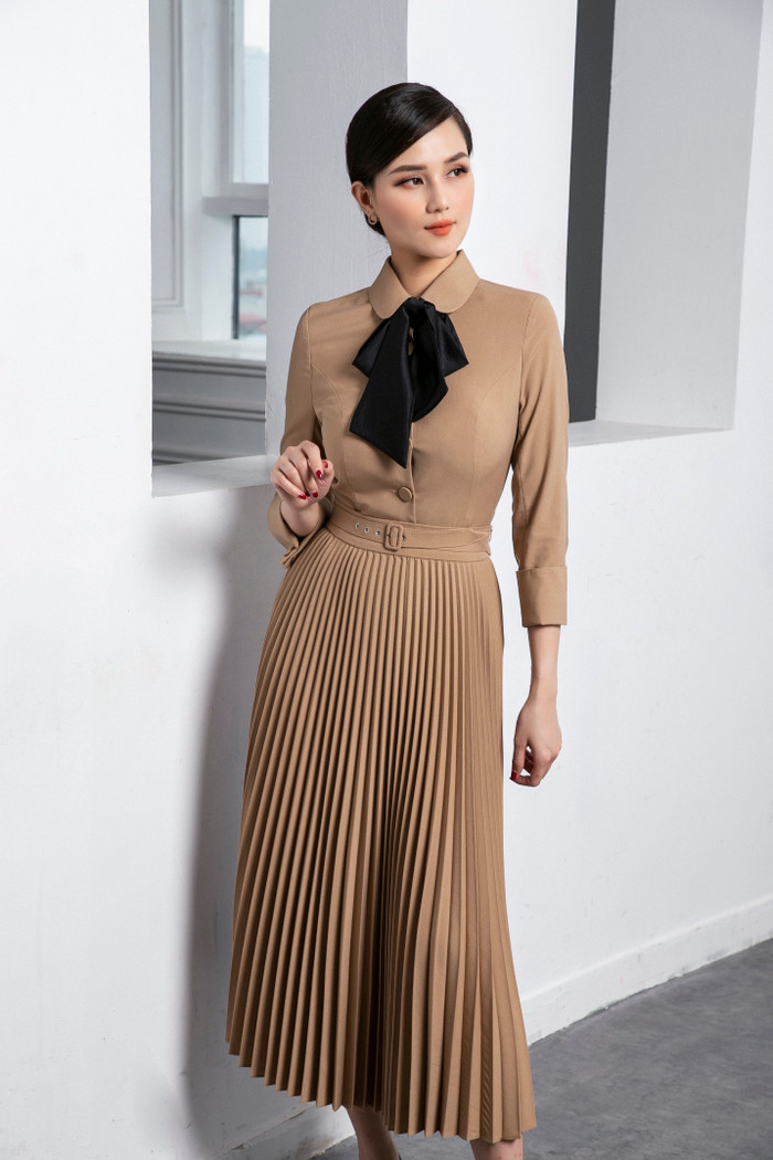 Set đồ gam màu be với váy xếp ly nổi bật .