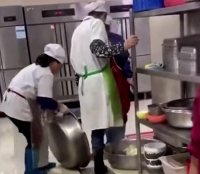 Nhân viên này liên tục dùng chân vẫn còn đang mang đôi ủng để rửa rau