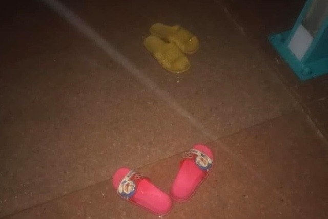 Người phụ nữ ôm 2 con để dép và xe máy trên cầu Thạch Bích rồi về nhà người thân. Ảnh: Dân Trí