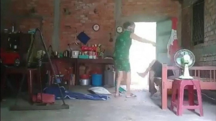 Bà Hoa (áo xanh) bạo hành mẹ già. Ảnh cắt từ clip