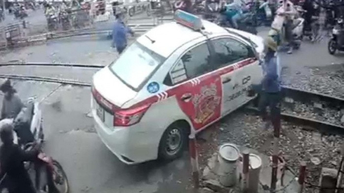 Hình ảnh ô tô taxi bị mắc kẹt bánh ngay tại đường ray.