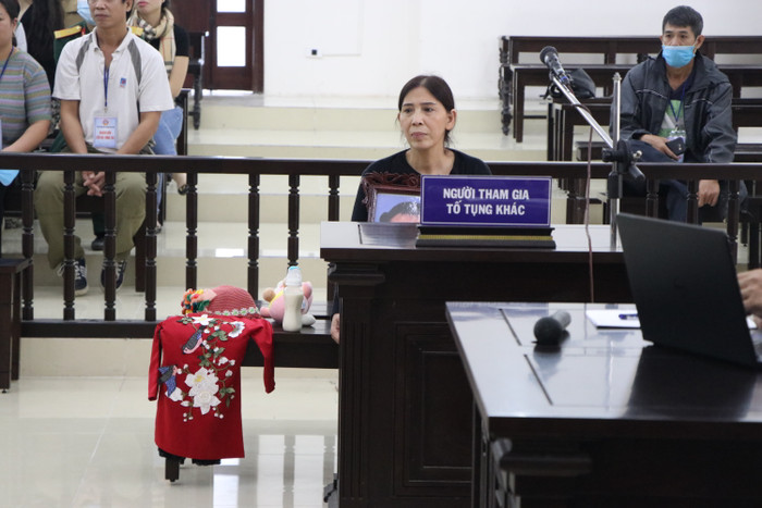 Bà Dự cầm theo di ảnh cháu gái đến toà.