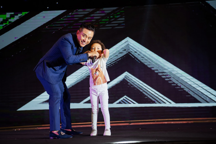 Cậu bé khiến nhiều người thích thú khi lí lắc, lên sân khấu biểu diễn minh họa cho bố.