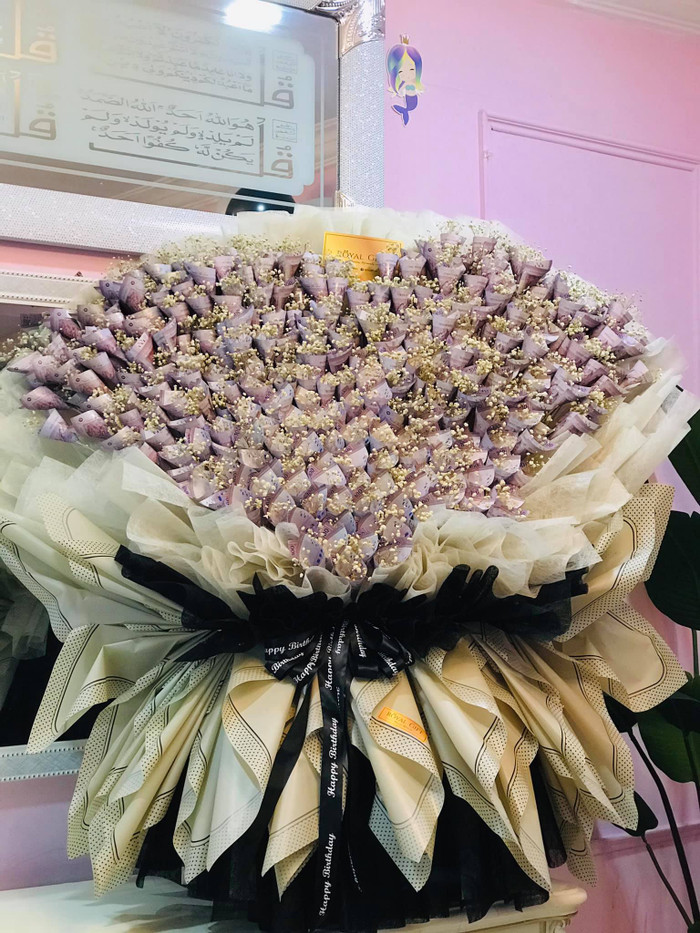 Những tờ tiền màu tím được xếp sát nhau, đan xen với những bông hoa baby khiến bó hoa thêm phần bắt mắt.