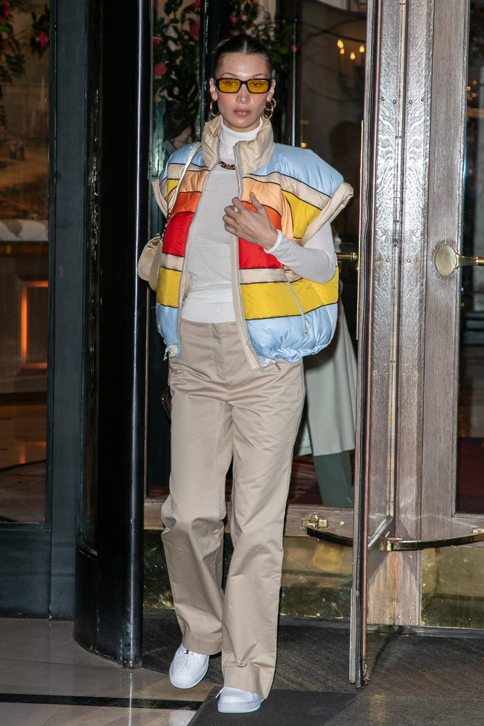 Áo phao và áo gi-lê đã trở thành xu hướng thịnh hành vào đầu những năm 2000 rồi tiếp tục nổi lên như trang phục gắn liền với nhiều môn thể thao. Bella kết hợp áo khoác với áo Cos cổ lọ, quần ống rộng Helmut Lang, giày thể thao Nike Air Force 1 và kính râm Arnette x Post Malone. 