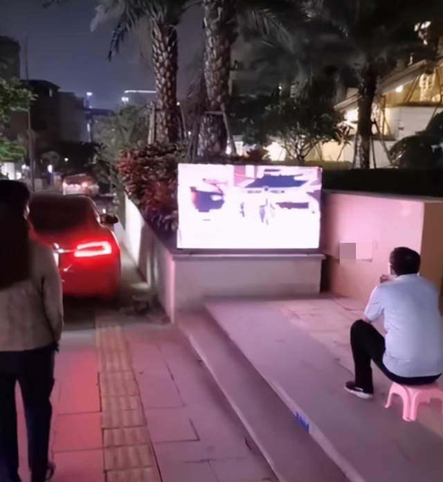 Ông bố ngồi xem ti vi ngoài đường nhận được sự tò mò của nhiều người qua đường