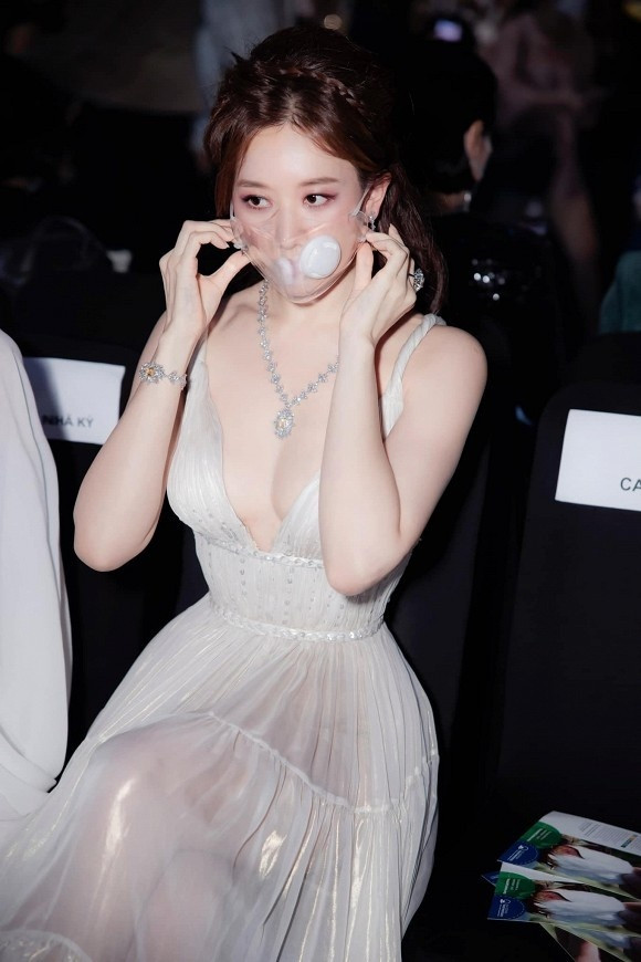 Hari Won diện váy trắng xẻ ngực sâu trong suốt không quên giữ sức khỏe bằng việc đeo khẩu trang trắng trong vừa có thể thở được lại nhìn trendy cực kì