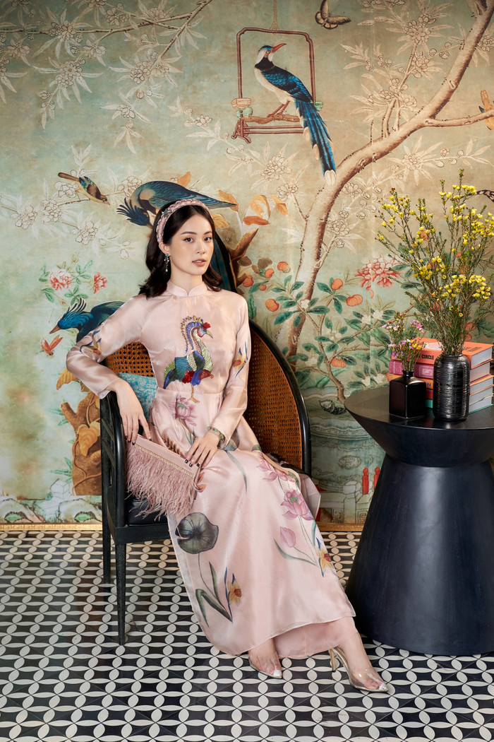 Hạ Vi chọn cho mình áo dài với họa tiết chim công và họa sen với gam màu hồng phấn ngọt ngào