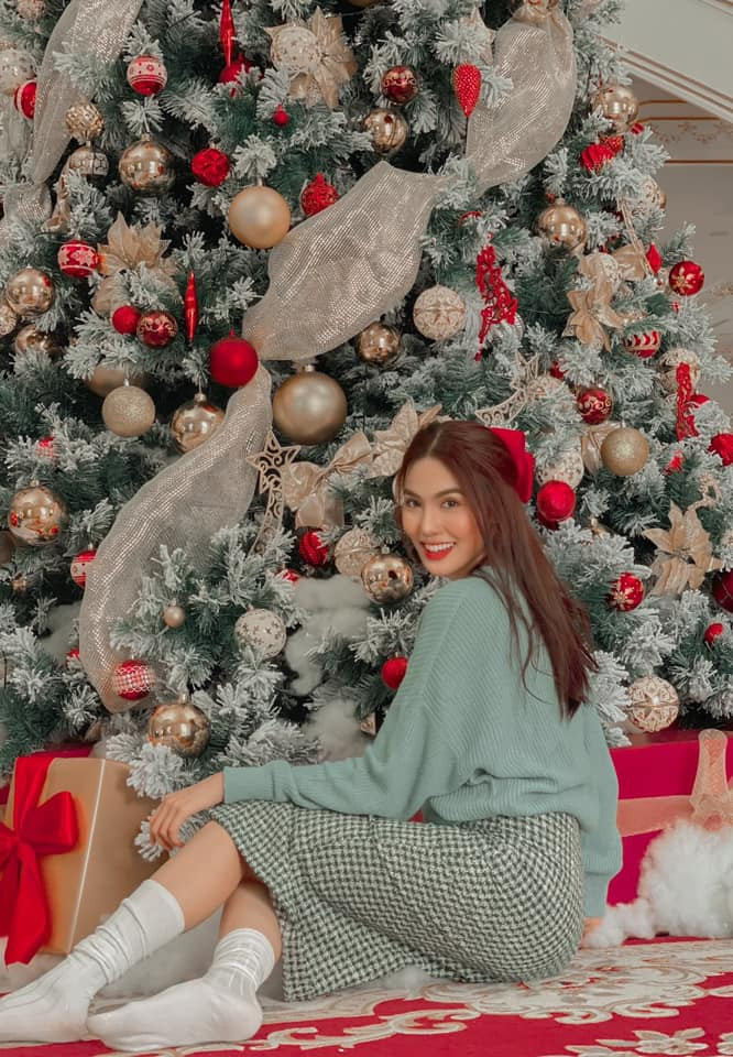 Lan Khuê diện trang phục với style đậm chất không khí Giáng sinh khi cô kết hợp áo len màu xanh mix cùng chân váy kẻ ô