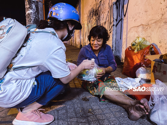 Tại ngã tư đường Lý Thường Kiệt - CMT.8, Cô N.T.M nở nụ cười tươi kể lại: 'Cũng may nhờ có tấm chăn, tấm áo ấm của các nhóm thiện nguyện về đêm nên cô mới chống chọi được qua cái thời tiết rét buốt của mùa lạnh này.'