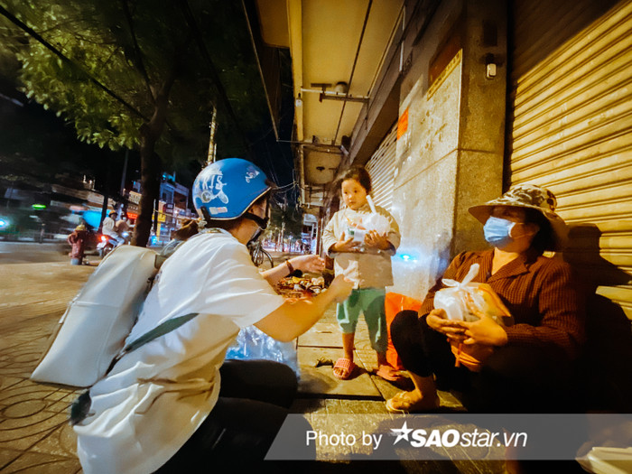 Những người không nhà, phải lang thang và ngủ ngoài lề đường tại Sài Gòn rất đa dạng, từ các cụ ông, cụ bà, phụ nữ và cả trẻ em. Em bé trong hình khi nhận được quà đã ngoan ngoãn khoanh tay cúi chào cảm ơn các cô chú. 