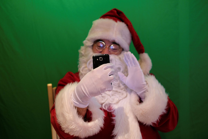 Do ảnh hưởng của dịch COVID-19, nhiều ông già Noel trên thế giới không thể gặp trực tiếp các em nhỏ. Dẫu vậy, điều này không thể ngăn ông già Noel tại Bồ Đào Nha gặp mặt các cháu nhỏ thông qua tính năng gọi video trên điện thoại. (Ảnh: Reuters)