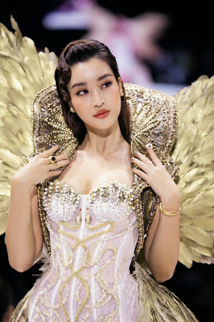 Hoa hậu Việt Nam 2016  mang phom dáng corset kết hợp cùng phần váy khoác ngoài. Chi tiết đính kết đá cầu kỳ được sắp xếp đến tận đuôi váy ôm sát thân hình gợi cảm của cô 