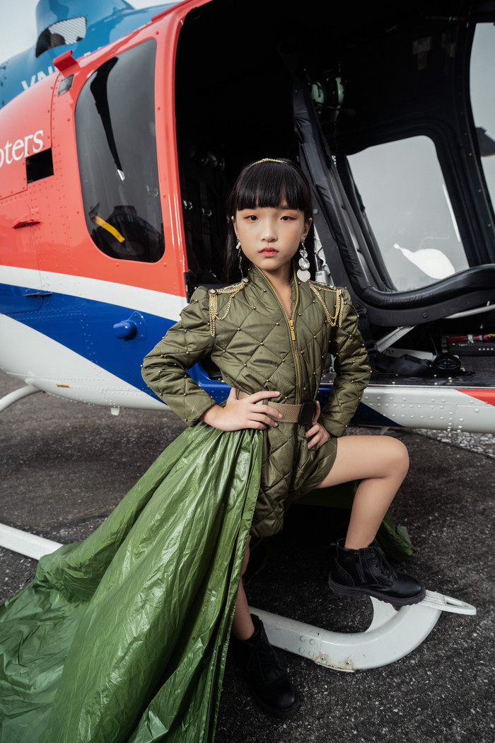 Cô bé chọn cho mình trang phục theo phong cách 'army' màu xanh rêu tự tin pose dáng bên cạnh trực thăng 