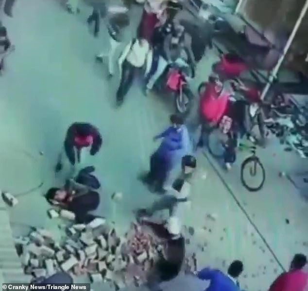 Hai người đàn ông bị đống gạch rơi vào người khi đang đi trên đường.