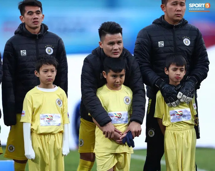 Cầu thủ Quang Hải choàng lên người em nhỏ cho đỡ lạnh. Ảnh: Nhịp sống Việt