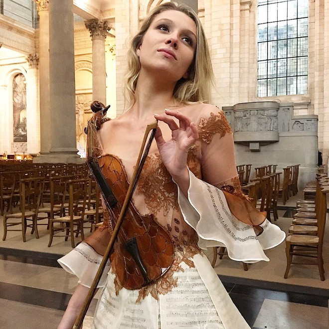 Phần thân trên của chiếc váy này được tạo hình đàn violin với những bản nhạc lãng mạn. Các chi tiết như vải xuyên thấu, ren, bèo nhún góp phần tôn lên diện mạo nữ tính, quyến rũ cho người mặc. 