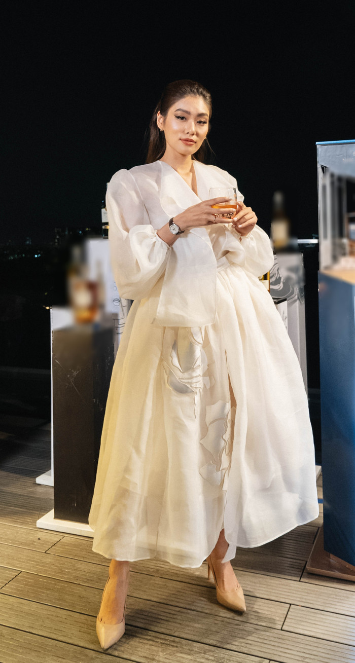 Người đẹp thả dáng trong chiếc váy trắng bềnh bồng, đắp hoạ tiết hoa hồng của NTK Trần Hùng. 