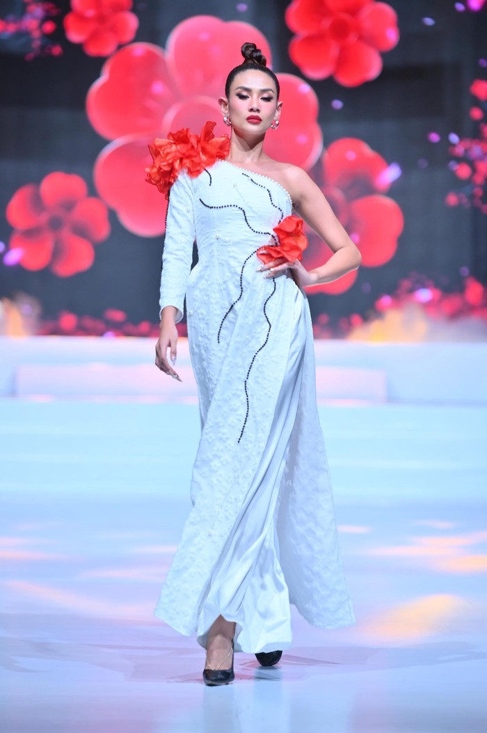 Võ Hoàng Yến trong bộ áo dài trắng cách tân lệch vai điểm xuyến những bông hoa đỏ 