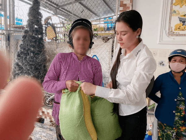 Vợ của cố ca sĩ Vân Quang Long phát gạo cho bà con.