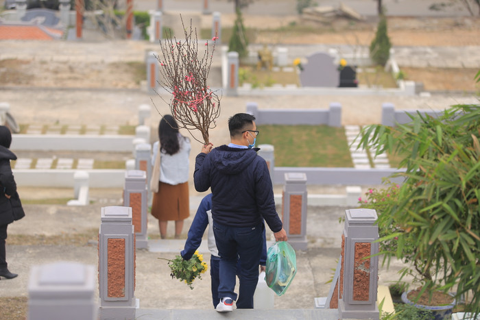 Nhiều người dân thủ đô mang theo đào quất đã lên đây dọn dẹp, mời gia tiên về đón Tết. 