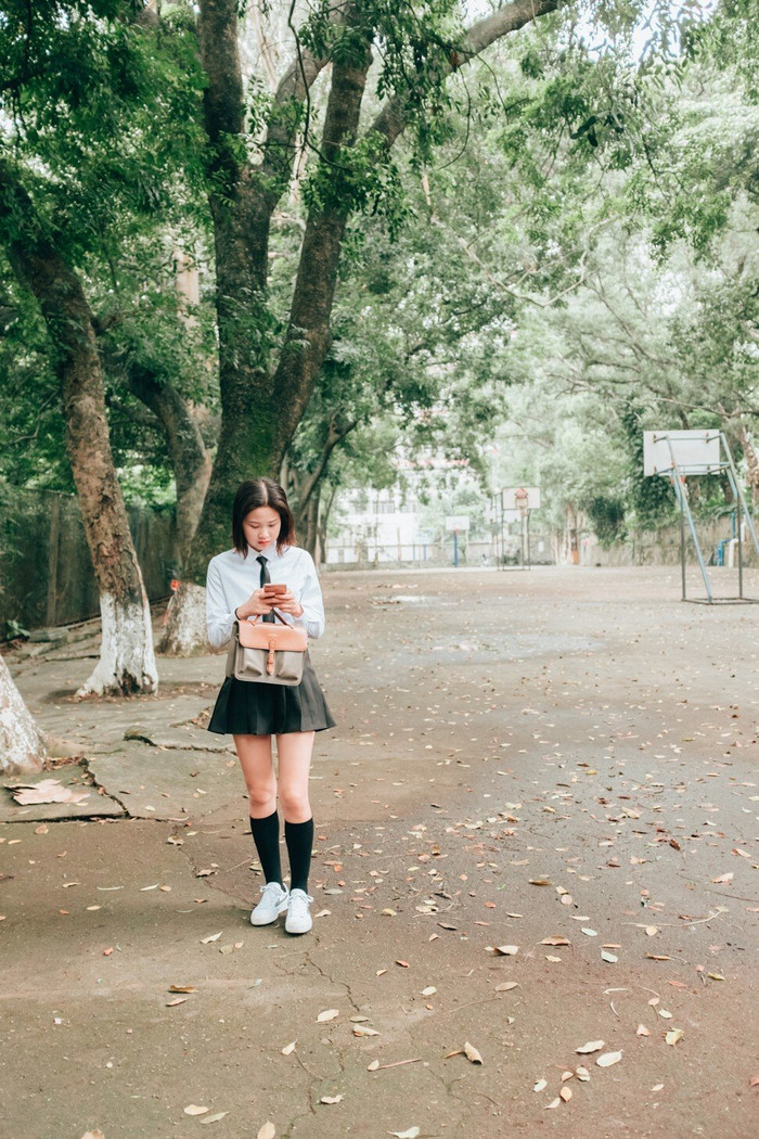 Một học sinh nữ đang dùng điện thoại thông minh trong khuôn viên trường. (Ảnh: Getty Images)