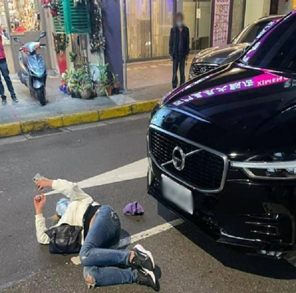 Người phụ nữ thản nhiên nằm giữa đường lướt điện thoại sau vụ va chạm. 