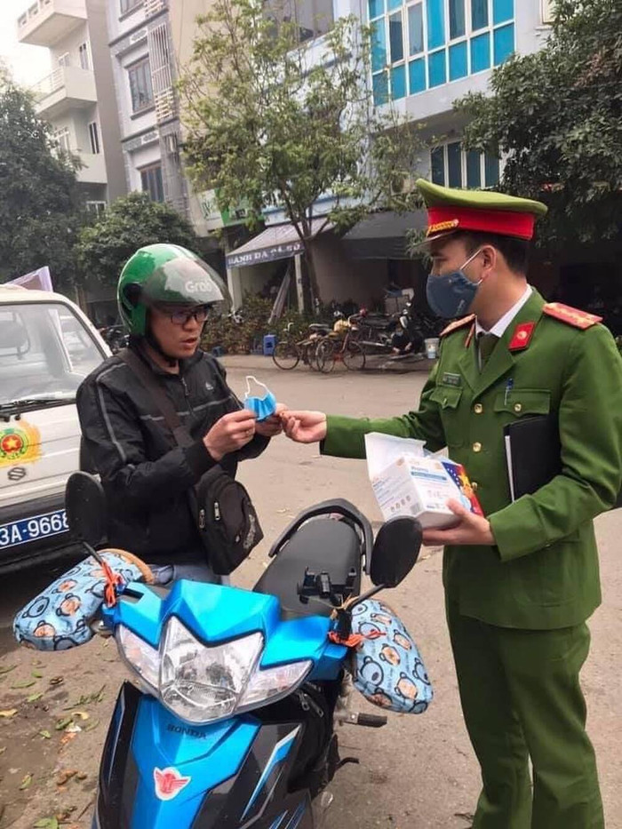 Công an nhắc nhở người dân đeo khẩu trang.