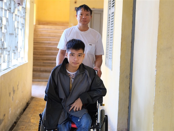 Sinh viên Nguyễn Tất Minh được bố là Nguyễn Văn Mây đẩy xe lăn tới giảng đường mỗi ngày