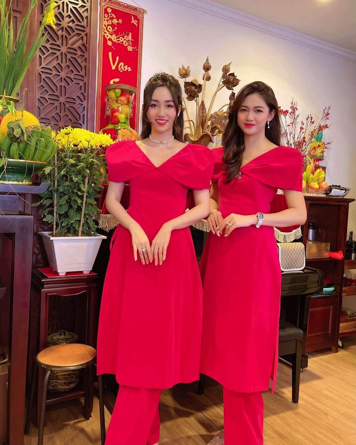 Hai chị em á hậu Ngô Thanh Thanh Tú, Ngô Trà My sánh đôi cùng nhau trong tà áo dài màu đỏ cách tân nhẹ nhàng. 