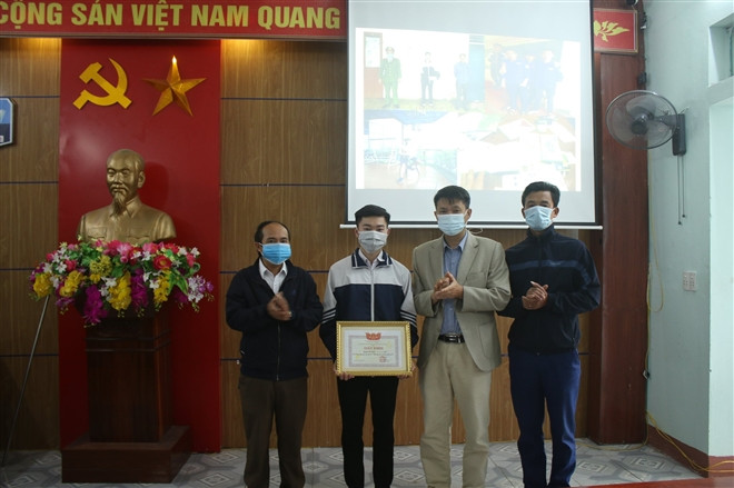 Lãnh đạo trường THPT Nguyễn Huệ trao giấy khen cho em Nguyễn Việt Thạch.