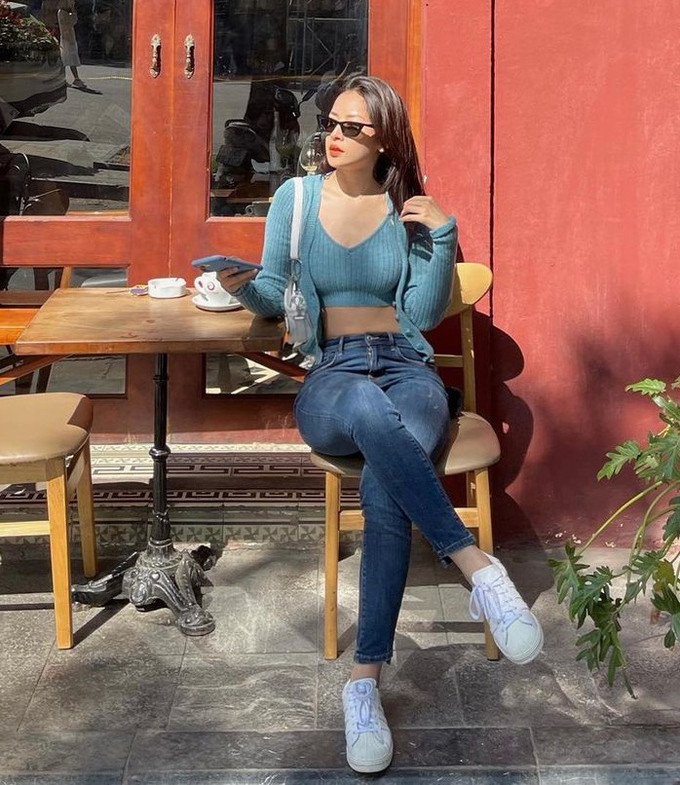 Chi Pu ưu ái kiểu áo dây có cổ tim đi cùng áo khoác ngoài chất liệu sợi dệt thoi mềm mại. 