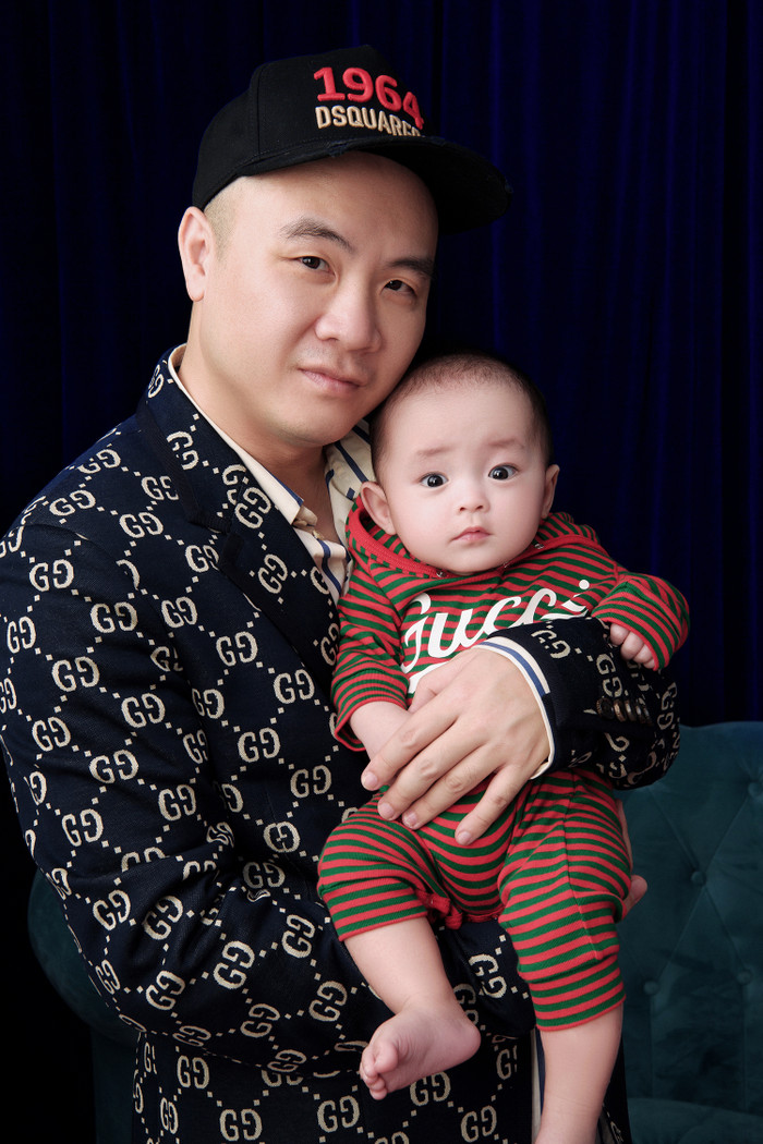 Rồng (Đỗ Phạm Hoàng Long) diện bodysuit với hoạ kẻ sọc màu nổi. Đây là con nuôi thứ bảy của NTK Đỗ Mạnh Cường. Anh nhận bé vào tháng 10/2020. Hiện, Rồng khoẻ mạnh, đã gần 9 tháng tuổi