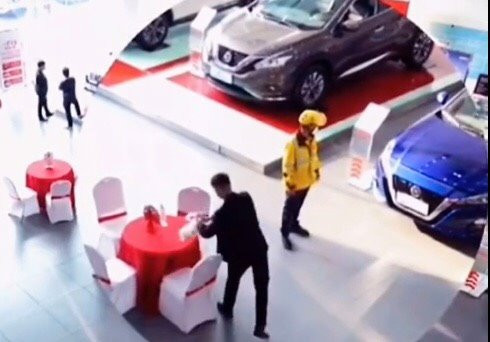 Chàng shipper ngắm nghía những chiếc xe khi anh tới giao đồ ăn.