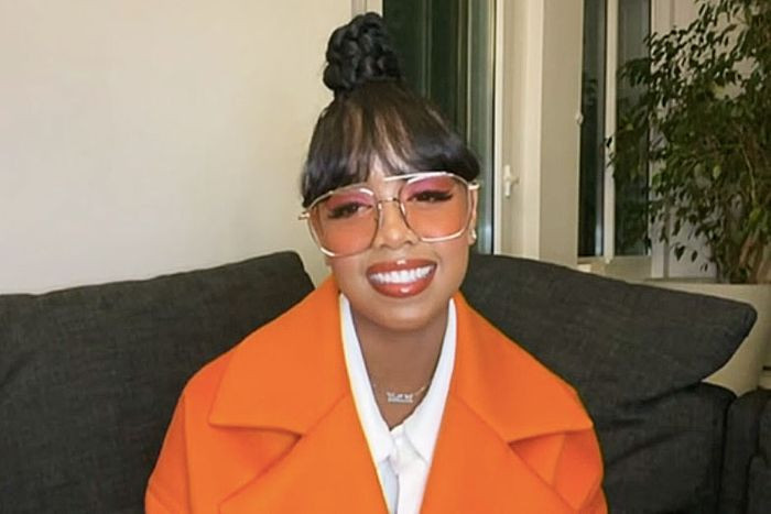 Phần trang điểm đậm, kiểu tóc búi và chiếc áo cam khiến HER trông giống như một... củ cà rốt.