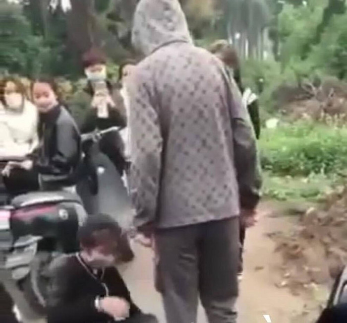 Nữ sinh bị đánh hội đồng ngã xuống đất, không dám phản kháng. 