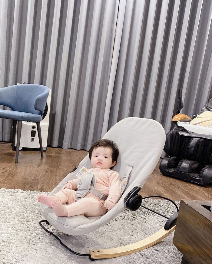 Winnie được đặt ngồi trên chiếc ghế chuyên dụng cho em bé và theo dõi ca khúc thiếu nhi BINGO.