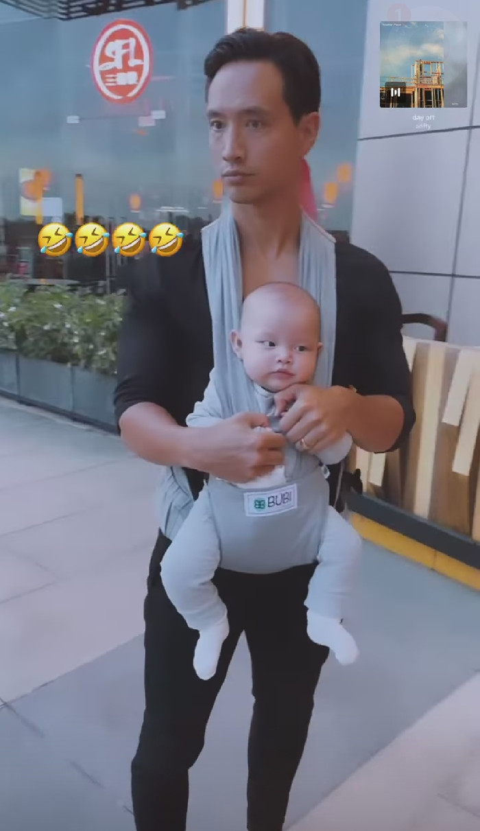 Chiều chiều, Kim Lý cùng Hà Hồ địu con xuống phố, chồng bế con trai, vợ ôm con gái.
