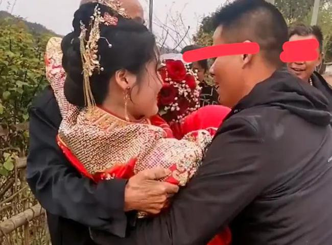 Cô dâu ngượng ngùng, khó xử khi được bố chồng bế từ xe hoa vào nhà.