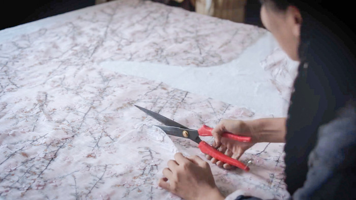 Để chuẩn bị cho buổi du xuân cùng bà, Lý Tử Thất đã tự tay may một bộ đồ cổ trang để mặc khi đi ngắm hoa đào. (Ảnh: Liziqi / YouTube)
