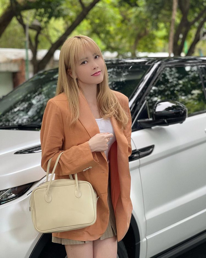 Thiều Bảo Trâm hóa nữ chủ tịch đứng tạo dáng bên xế hộp