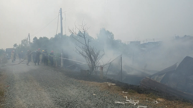 Lực lượng chức năng phun nước làm mát tránh lửa bùng phát trở lại. Ảnh: Trần Kha/Thanh Niên