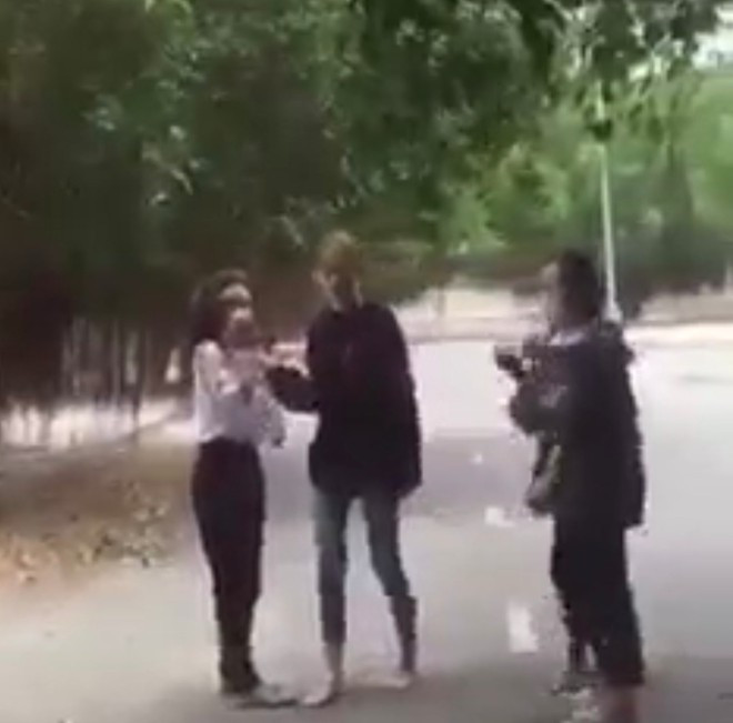 Nữ sinh mặc đồng phục học sinh bị 2 bạn nữ mặc áo đen đánh. Ảnh cắt từ clip