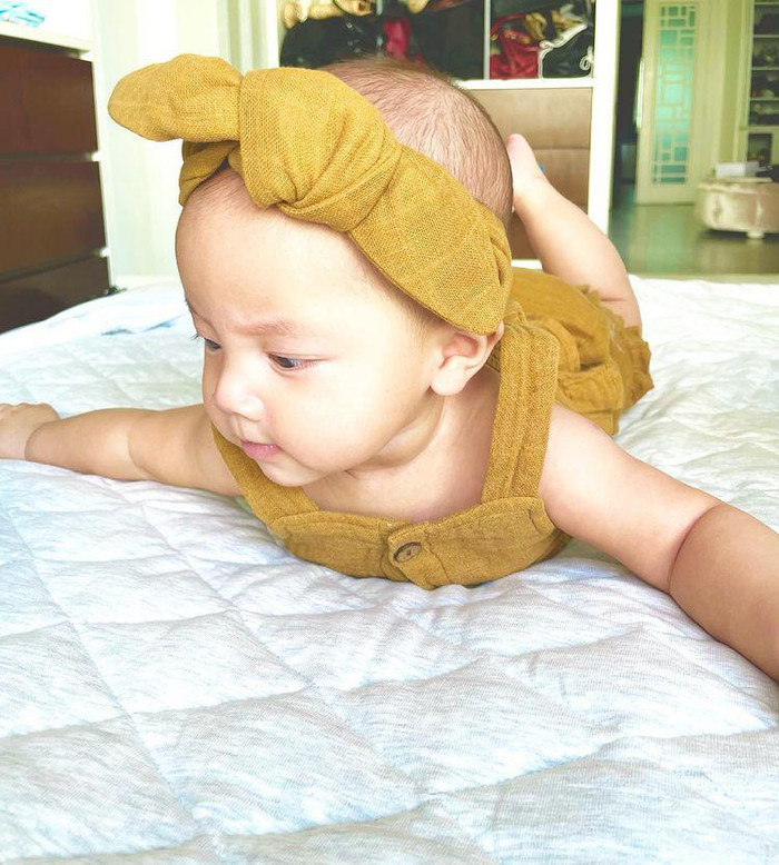 Điểm khác biệt ngoài phần bèo nhún nơi áo của Lisa thì bé còn được cho cài chiếc nơ cùng chất liệu. 