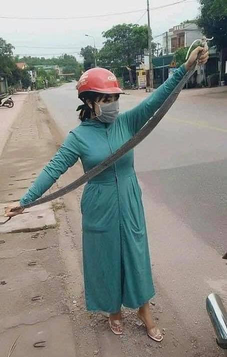 Người phụ nữ tay không bắt rắn khiến nhiều người kinh hãi. 