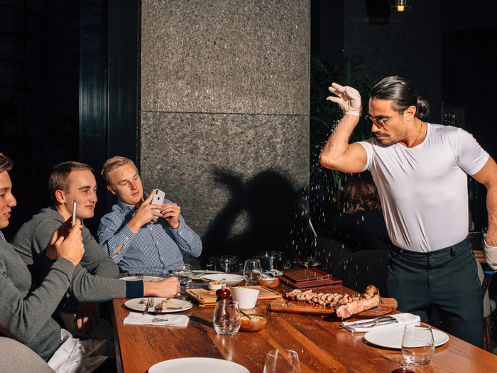 'Thánh rắc muối' Salt Bae biểu diễn màn rắc muối đặc trưng của mình tại nhà hàng bít tết Nusr-Et ở Manhattan. (Ảnh: Cole Wilson / The New York Times)