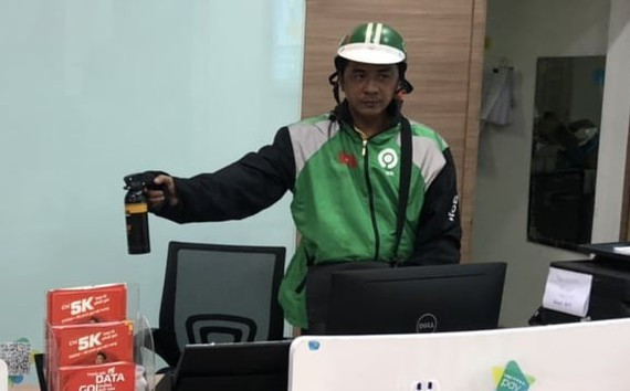 Nguyễn Thiên Ngọc xông vào cửa hàng, dùng bình xịt hơi cay tấn công nữ nhân viên. Ảnh: SGGP